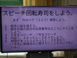 モニターにスピーチ回転寿司をしようと書かれルールなどが映し出された写真