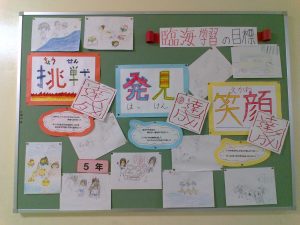 臨海学習の目標と、手書きのイラスト画像や挑戦・発見・笑顔の言葉の横に達成!!と書かれたシールが貼られている写真