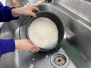 長し台でお米を洗っている様子の写真