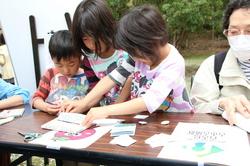 缶バッチつくりを体験する子供たちの写真