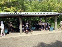 屋根のついた開放感ある炊事棟で、子どもたちが集まって作業をしている写真
