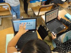 開いたタブレットの画面と、子どもがタブレットを操作している手元を写した写真