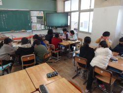 机をグループごとに分けて着席している子どもたちが話し合いを行っている様子の写真