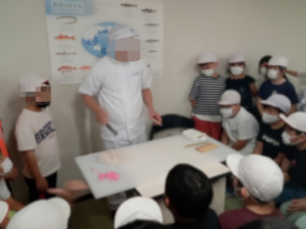 3年社会見学 職員さんから話を聞いているようす