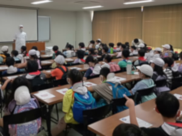 3年社会見学 部屋で話を聞いている大勢のようす