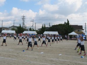 縦3列に並び、肩幅くらいに足を開き、ポンポンを持って踊っている写真