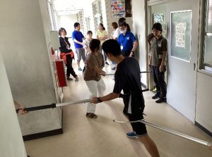 不審者役の方をさすまたでどう押さえるかアドバイスをもらいながら訓練している写真