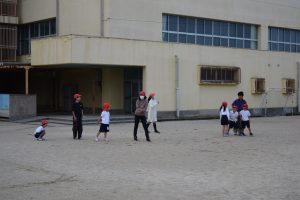 身長差のある生徒たちが校庭で一緒に遊んでいる様子の写真