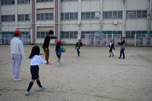 身長差のある生徒たちが線が引かれた枠内に集まって一緒にボール遊びをしている様子の写真
