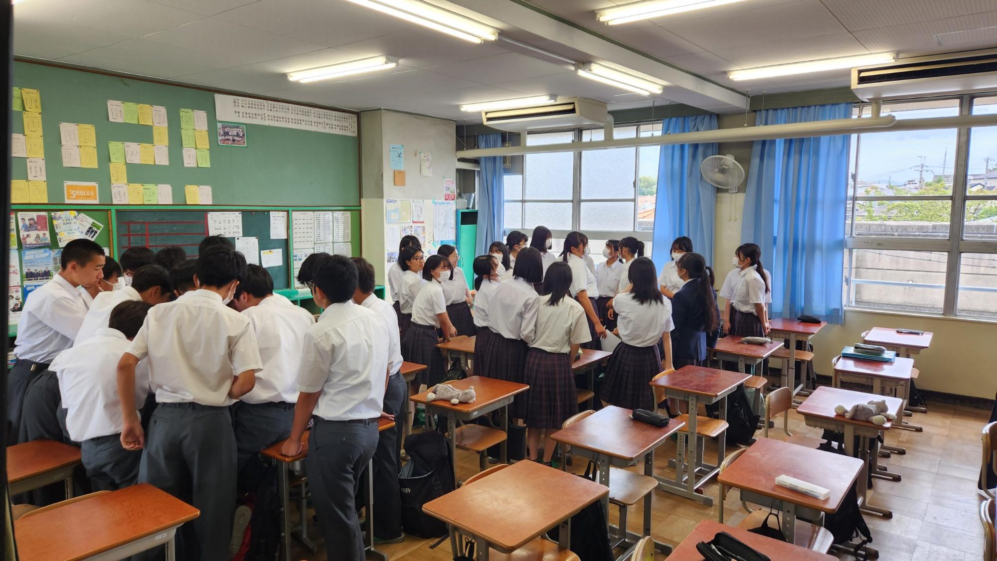 教室の後方に男子生徒と女子生徒が分かれて集まり、体育大会のメンバーを決めている様子の写真