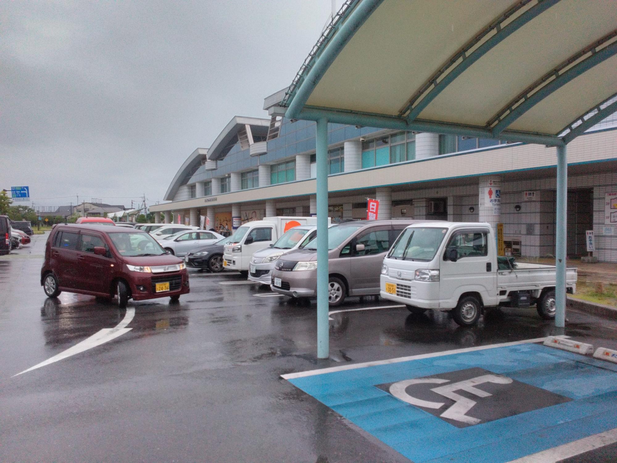 トイレ休憩に訪れた施設の前の駐車場に沢山の乗用車が駐車している様子の写真