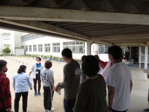 運動場に隣接している渡り廊下に先生方が集まり、話し合いをしている様子の写真
