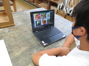 一人の 児童がタブレットの前に座っており、タブレットの画面には6枚の写真が映し出されているオンライン国際クラブOSAKAの様子の写真