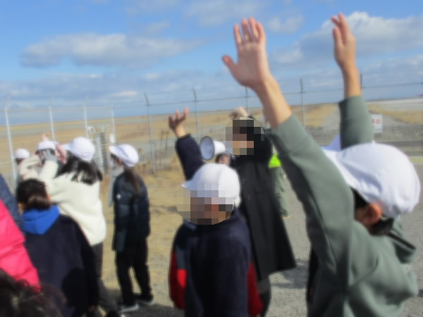 飛行機に手を振る子どもたち