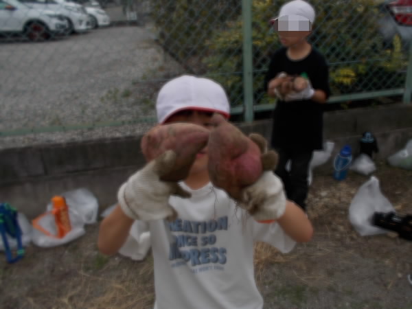 おおきなさつまいもをもっている子ども