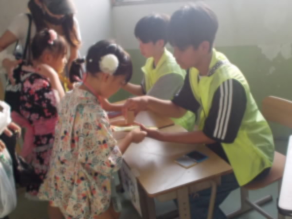 250823_受付ではんこをおしてもらう子ども
